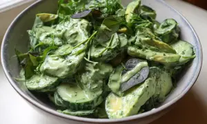 En krämig green goddess sallad med avokado, gurka och färska örter i en skål.