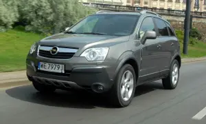 Szary Opel Antara 2.0 CDTI w ruchu miejskim, z widocznym numerem rejestracyjnym WE 7979 J.