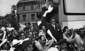 Gamal Abdel Nasser, drugi prezydent Egiptu, pozdrawia tłum z otwartego samochodu.