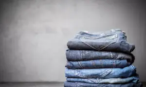 Stosik złożonych jeansów, każdy w innym odcieniu niebieskiego. Z czego jest jeans? Z bawełny, tkanej diagonalnie, co nadaje mu wytrzymałość.