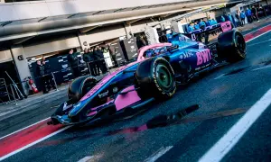 Coche de **Alpine F1** azul y rosa listo para la carrera en el pit lane.