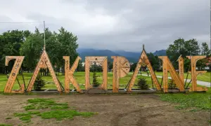 Drewniany napis "ZAKOPANE" na tle gór. Idealne miejsce na rozpoczęcie poszukiwań zakopane atrakcje dla dorosłych.
