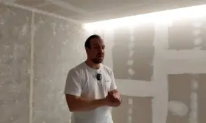 Mężczyzna prezentuje wnękę na led w suficie, która tworzy nowoczesne oświetlenie.