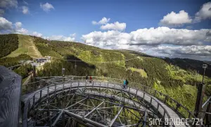 Spacer w chmurach Czechy. Drewniana kładka Sky Bridge 721 w Dolní Moravie wznosi się nad zielonymi lasami i górami.