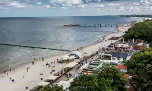 Plaża nad Bałtykiem, molo, restauracje i spacerowicze. Idealne miejsce na tanie wczasy we wrześniu w Polsce.