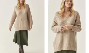 Kobieta w beżowym swetrze oversize i zielonej spódnicy. Stylowe połączenie na co dzień.