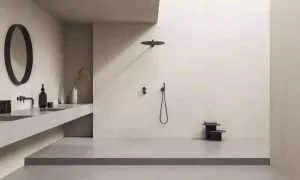 Minimalistisches Bad mit offener Dusche. Die bodentiefe Dusche ist so gestaltet, dass Spritzwasser vermieden wird. Ein runder Spiegel und ein schwebendes Waschbecken ergänzen den Look.