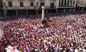Multitudinaria plaza en las fiestas del Torico de Teruel, con gente vestida de blanco y rosa celebrando.