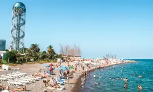 Tłum ludzi na plaży w Batumi, Gruzja. W tle charakterystyczna wieża. Odpowiedź na pytanie: czy w Gruzji jest bezpiecznie? Tak, plaże są pełne turystów.