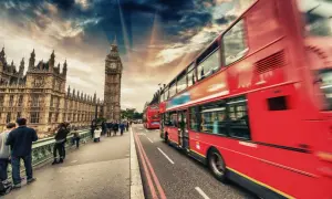 Londyn: czerwone autobusy i Big Ben na tle dramatycznego nieba.
