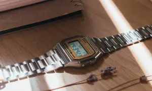 Reloj Casio plateado sobre madera. Aprende como saber si un reloj es original observando sus detalles.