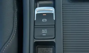 Przycisk auto hold w samochodzie. Ułatwia postój, zapobiegając stoczeniu się pojazdu.