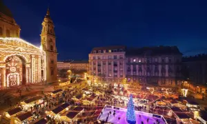 Magiczny budapeszt jarmark bożonarodzeniowy. Tłumy ludzi na lodowisku i przy straganach, oświetlona bazylika w tle.