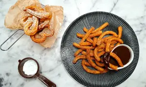 Churros przepis: złociste, chrupiące paluszki posypane cukrem pudrem i cynamonem, podane z gorącą czekoladą. Idealne na deser!