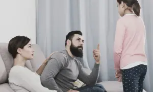 Una bambina ascolta il padre che la ammonisce, mentre la madre, con un'espressione preoccupata, le appoggia una mano sulla spalla, forse per alleviare la sua paura di perdere i genitori.
