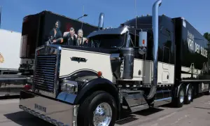 Beau camion américain Kenworth noir et crème, avec une peinture personnalisée sur la remorque.