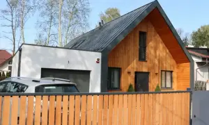 Nowoczesna dobudówka do starego domu, z drewnianą elewacją i garażem. Projekty architektoniczne łączące tradycję z nowoczesnością.