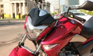 Błyszczący, czerwony motocykl Suzuki Inazuma z czarnym akcentem na przedniej owiewce, gotowy do jazdy po mieście.