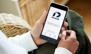 Person håller upp en telefon med BankID-appen öppen, redo för inloggning eller underskrift. Perfekt för din bankID ny telefon.