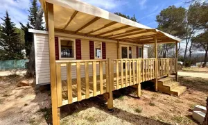 Mobil-home avec terrasse en bois sous un auvent, dans un cadre verdoyant. Une image qui pourrait illustrer la jurisprudence mobil-home.