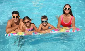 Famiglia felice in piscina, in attesa dello stipendio 15 agosto. Sorrisi e occhiali da sole per tutti!