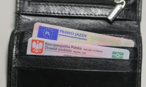 Czarny portfel z polskim dowodem osobistym i prawem jazdy. Na dokumencie prawa jazdy widnieje napis "prawo jazdy" oraz symbol UE. Na dowodzie osobistym widnieje godło Polski i napis "Rzeczpospolita Polska". Prawo jazdy ograniczenia 71.