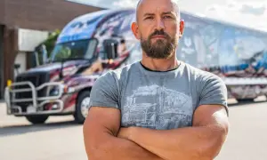 Dawid Andres, w sile wieku, z brodą, stoi przed ozdobioną ciężarówką.