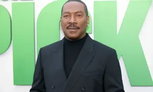 Eddie Murphy w czarnym garniturze, promujący swoje filmy.