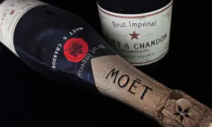 Dwie butelki szampana Moët & Chandon Brut Impérial na czarnym tle. Zastanawiasz się, ile szampan ma procent? Zwykle 12%.