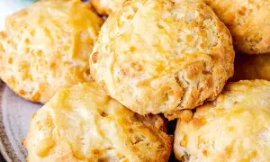 En hög med gyllene, fluffiga ostscones, perfekta för en mysig fika.