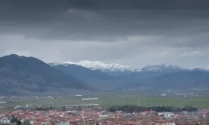 Widok na miasto Korce w Albanii z ośnieżonymi górami w tle.