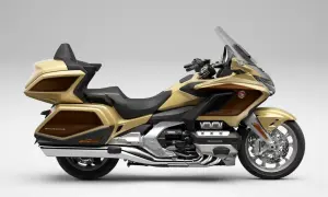 Złoty Honda Goldwing, luksusowy motocykl turystyczny z brązowymi akcentami, gotowy na dalekie podróże.