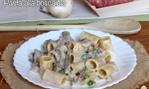 Piatto di pasta alla boscaiola con funghi, piselli e salsiccia, servita su un piatto bianco con un tovagliolo di juta.