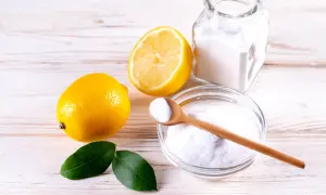 Limoni, bicarbonato e una ciotola con la struttura dell'acido citrico, pronti per un rimedio naturale.