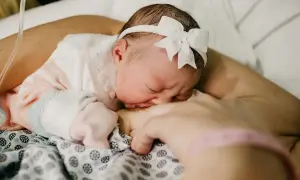 Nowe życie, maleńka główka z kokardką, przytulona do mamy. To nie jest śmierć łóżeczkowa, to początek.