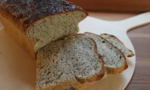Nybakad limpa med vallmofrön, perfekt att baka bröd med gräddfil till. Skivorna ligger på en träskärbräda.