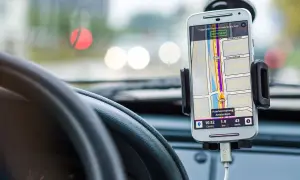 En mobiltelefon med GPS visar vägen i bilen. Föraren kan prata i telefon medan navigeringen pågår.