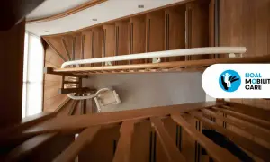 Montascale a poltroncina installato su scala condominiale in legno. Ottenere l'autorizzazione installazione montascale condominio è fondamentale per l'accessibilità.