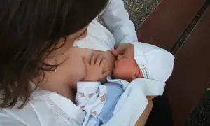 Mama karmi piersią dziecko. Czas karmienia jest indywidualny, ale ważne, by maluch był najedzony.