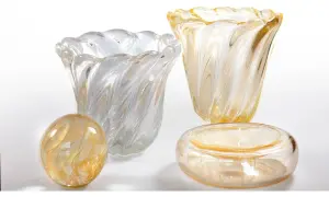 Vasi e oggetti decorativi in vetro soffiato, con fili dorati e bianchi, che evocano la maestria di Seguso Vetri d'Arte.