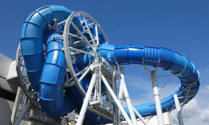 Aquapark Reda: niebieska zjeżdżalnia z rekinami, która wygląda jak gigantyczny wir wodny, gotowa na przygody.