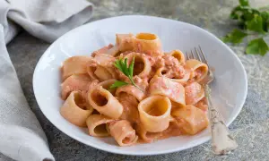 Un piatto di pasta al tonno cremosa, con paccheri conditi e guarniti con prezzemolo fresco.