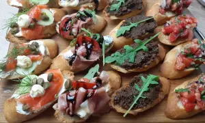 Kolorowe bruschetty na imprezę: z łososiem, szynką parmeńską, pomidorami i pastą z oliwek.