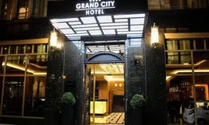 Elegancki **grand city hotel** nocą, z podświetlanym neonem i lśniącym wejściem.