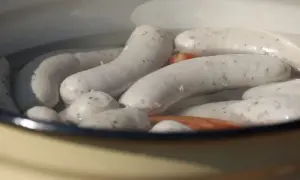 Weiße Würste garen in heißem Wasser. Die Frage "wie lange Wiener kochen" beschäftigt viele Hobbyköche.