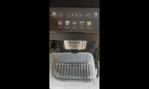 Panel sterowania ekspresu DeLonghi Magnifica Evo. Widoczne ikony napojów i przyciski. Przygotowanie do odkamieniania.