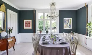 Elegant matsal med dukat bord, kristallkrona och konst. En vacker inspiration för att renovera sekelskifteshus.