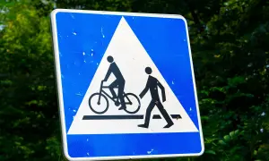 Znak ostrzegawczy: przejazd dla rowerzystów i pieszych. Uważaj na drodze, gdy widzisz ten symbol.