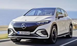 Biały Mercedes EQS SUV jedzie wzdłuż malowniczego wybrzeża.