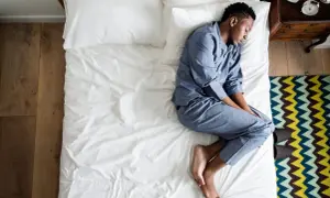 A man sleeps on his side, curled up. What does the way you sleep say about you?